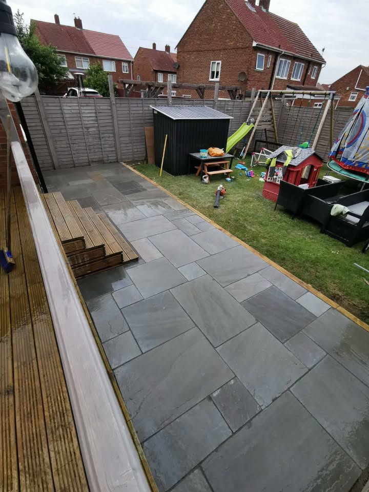Stone patio with timber decking steps and fencing