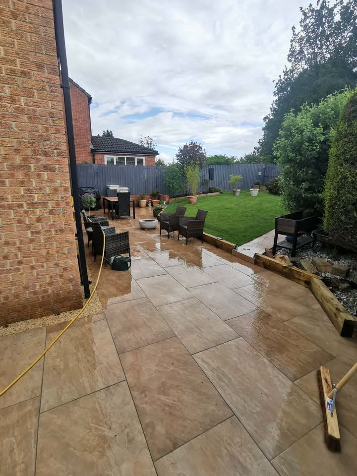 Stone patio with outdoor furniture, lawn and sleeper edging